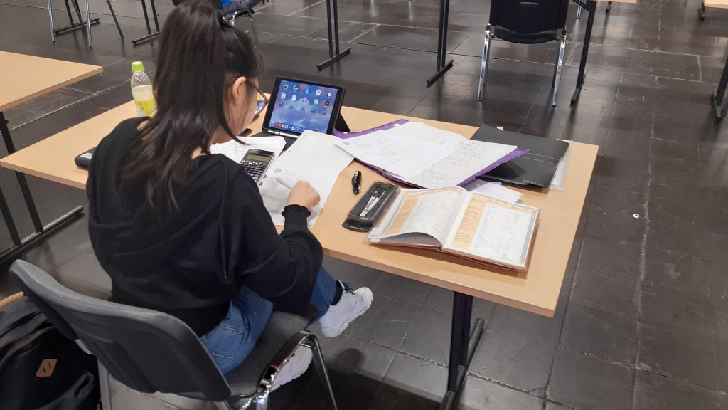 Studentin bei der Open-Book- und Open-Web-Präsenzprüfung mit analoger Einreichung in den Messehallen Magdeburg im Sommersemester 2021
