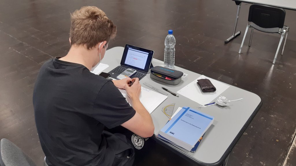 Student bei der Open-Book- und Open-Web-Präsenzprüfung mit analoger Einreichung in den Messehallen Magdeburg im Sommersemester 2021
